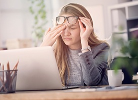 Tired woman at work, suffering from sleep apnea consequences