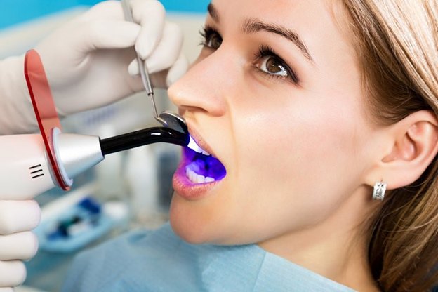 woman getting dental bonding hardened with curing light