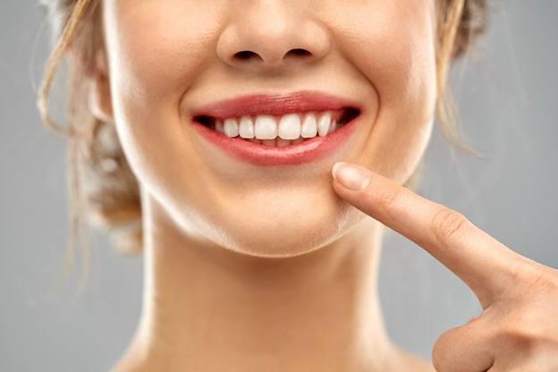 woman pointing to her straight white smile