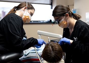 Woman looking at smile in mirror in dental chair