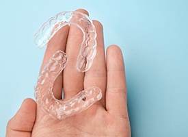 Clear aligners on palm of someone’s hand