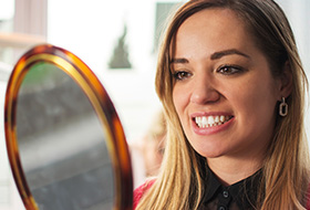 Woman looking at her smile in mirror