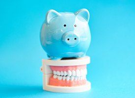  light blue piggy bank sitting on top of a set of dentures in Pittsburgh 