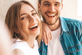 Man and woman with attractive teeth taking selfie
