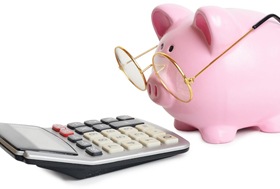 A piggy bank looking at a calculator