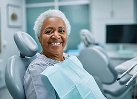 Woman smiling while seated in the dentist’s chair