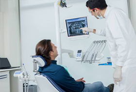 Dentist and patient looking at digital x-rays