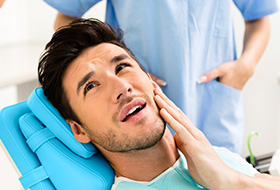 Man in pain holding jaw