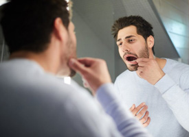 Man checking his teeth in the mirror