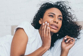 person holding their mouth in discomfort because of a cavity in Pittsburgh