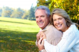 An older couple smiling outside.