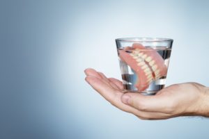 pair of dentures in a glass of water