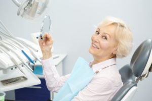 Woman with dental implants in Pittsburgh smiles while visiting her dentist