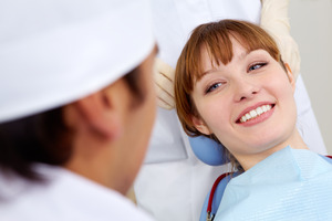 Red-haired female patient smiling at her dentist