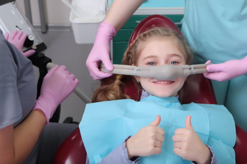 A child preparing for her treatment with a nitrous oxide nose mask