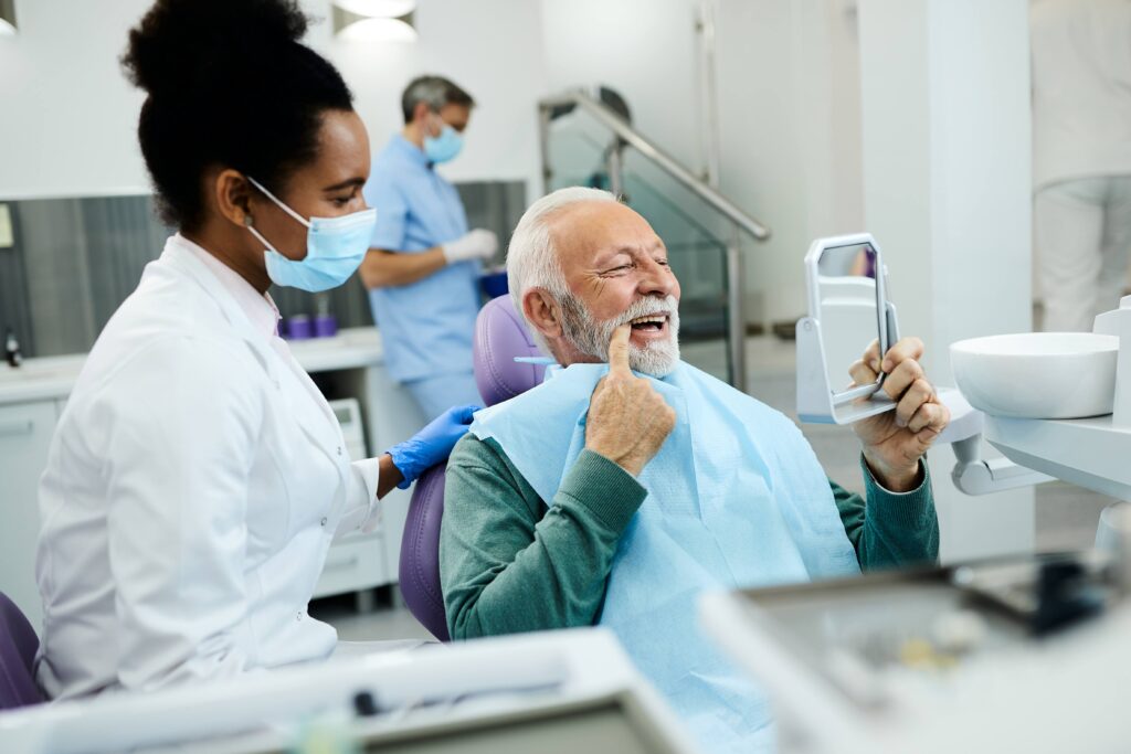 Patient looking at reflection in mirror with dentist